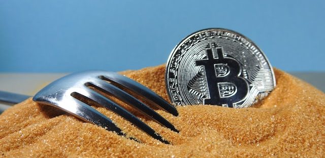 Symbol bitcoina na monecie i fork