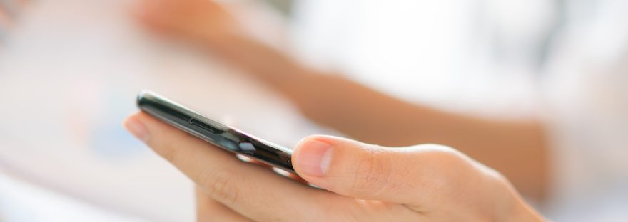 Kobieta trzyma telefon w dłoni