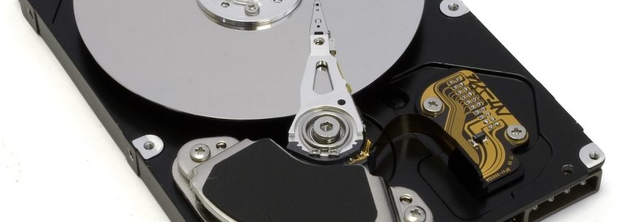 Otwarty dysk twardy HDD z widocznym talerzem i głowicą odczytu