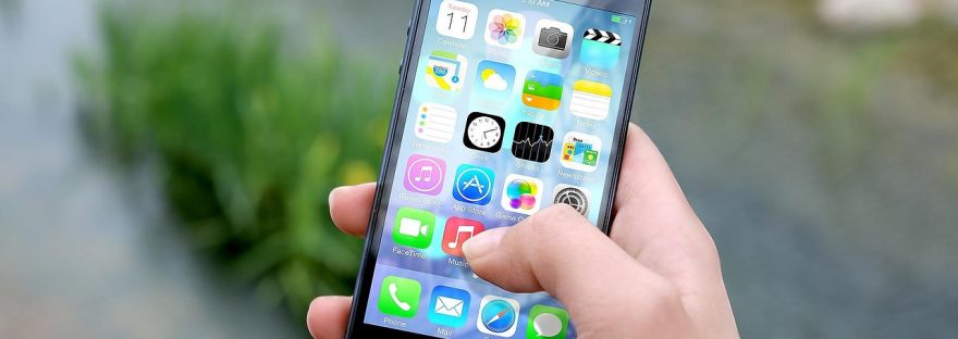 Osoba trzyma smartfon i przegląda aplikacje na ekranie głównym