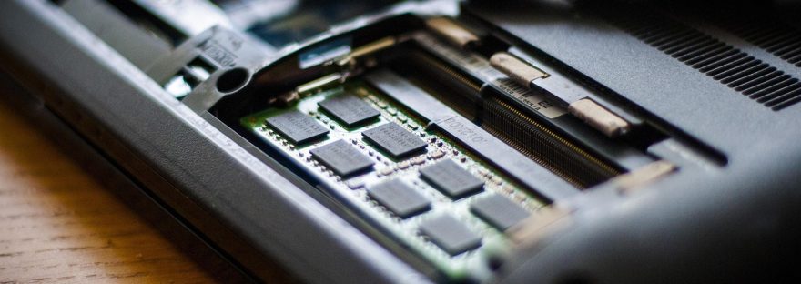 Moduł pamięci RAM montowany w slocie laptopa obok śrubokręta