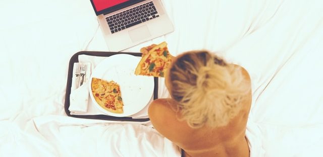 Kobieta leżąca na łóżku oglądająca Netflix