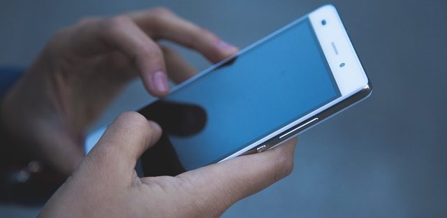 Osoba trzyma telefon w dłoniach